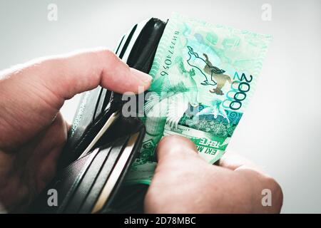 Open black wallet with tenge, Kazakhstan money in man's hands close-up. Stock Photo