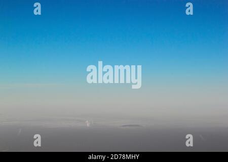 Smog over the Almaty city in the winter season under a clear blue sky Stock Photo