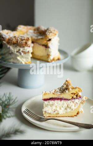 Polish Carpathian Mountain Cream Cake on blue ceramic cake stand. A piece of cake on the plate. Homemade karpatka. Stock Photo