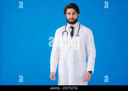 Young bearded doctor on a blue background. emotions of joy and a smile at the doctor looking at the camera Stock Photo