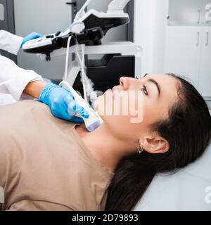 Female patient receives thyroid diagnostics at a medical clinic. Ultrasound diagnostics of the endocrine system and thyroid for a woman Stock Photo