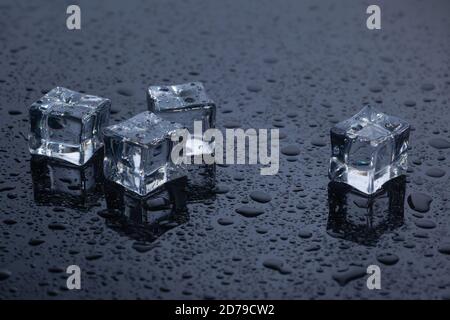 four ice cubes on black glass Stock Photo
