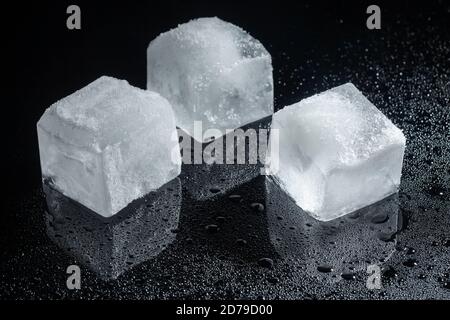 three ice cubes on black glass Stock Photo