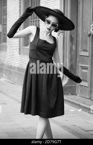 Black and white image of an Indonesian woman in a stylish pose looking down. Stock Photo