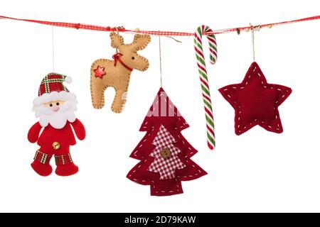 Various Christmas decorations hang on a decorative ribbon isolated on white background Stock Photo