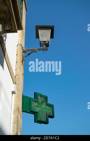 Looking at Pharmacy Green cross outdoor sign in the streets of Braga, Portugal Stock Photo