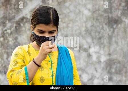 health problem and people concept - unhealthy indian woman coughing with nose mask on Stock Photo