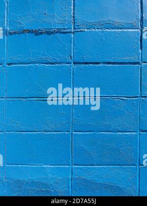 Vertical rows of old concrete blocks painted bright blue in the early morning light. Stock Photo