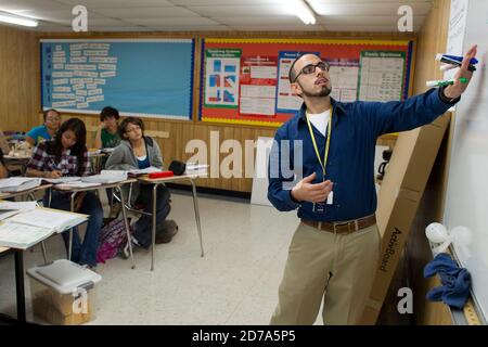Hispanic male teacher makes a point during class at Achieve Early College High School on the campus of South Texas College. The school, part of the highly regarded McAllen school district in South Texas on the US-Mexico border, enrolls nearly 500 students, almost 3/4 of whom come from economically disadvantaged families. Stock Photo