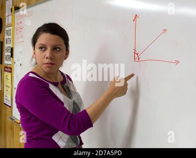 Hispanic female teacher makes a point during math class at Achieve Early College High School on the campus of South Texas College. The school, part of the highly regarded McAllen school district in South Texas on the US-Mexico border, enrolls nearly 500 students, almost 3/4 of whom come from economically disadvantaged families. Stock Photo