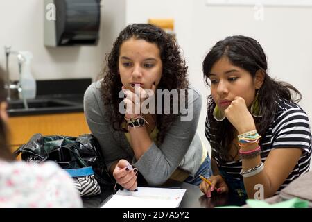 Female Hispanic students pay attention during science lab at Achieve Early College High School on the campus of South Texas College. The school, part of the highly regarded McAllen school district in South Texas on the US-Mexico border, enrolls nearly 500 students, almost 3/4 of whom come from economically disadvantaged families. Stock Photo