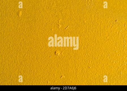 Close view of a wall painted yellow with globs spread from a dirty paint roller. Stock Photo