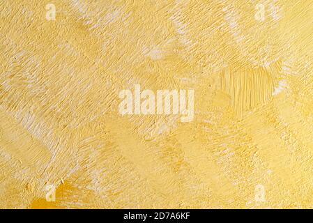 Close view of a background painted with white and yellow paint showing rough inconsistent brush strokes. Stock Photo