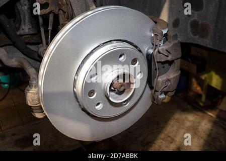 New brake disc with an anti-corrosion layer, mounted on the front hub. Stock Photo