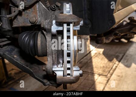 New anti-corrosion coated brake disc mounted on the front hub, a close-up shot of the brake disc internal ventilation system. Stock Photo