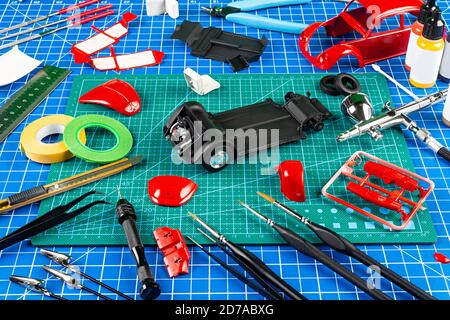 desktop view assembly and painting of a red retro scale model car vehicle  concept background. modeling tools airbrush gun paint kit parts blue green  c Stock Photo - Alamy