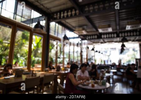 Blurred background of people in the cafe open space style. Social distance. Stock Photo