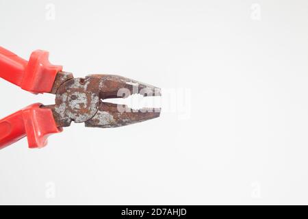 Side view of open rusty red pliers against white background Stock Photo