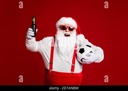 Portrait of his he attractive cheerful cheery fat white-haired Santa drinking beer holding soccer ball watching match isolated bright vivid shine Stock Photo
