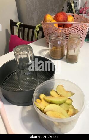 On the table are ingredients and tools for making charlotte. Autumn pie with apples. Stock Photo