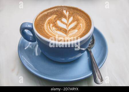 Ayurvedic coffee cappuccino cup in trendy american cafe. Milk foam in rosetta latte art Stock Photo