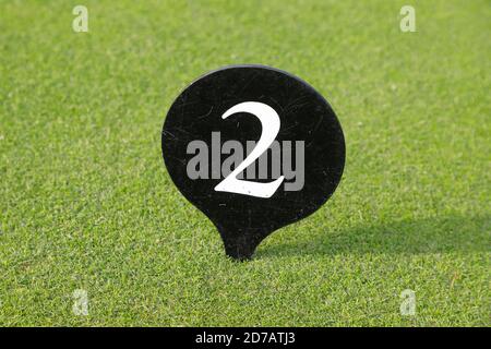White number two on a black plate against a green lawn background. Stock Photo