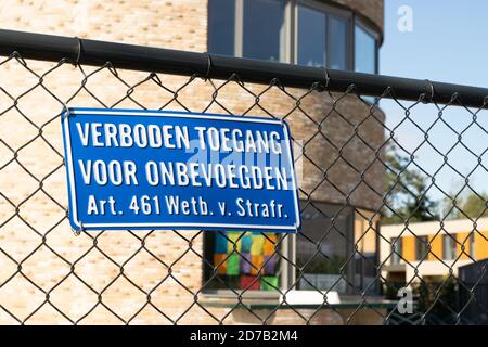 Sign attached to a fence with the Dutch text 'no entry for unauthorized persons, article 461 penal code' Stock Photo