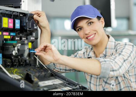 female technician fixing a printer Stock Photo