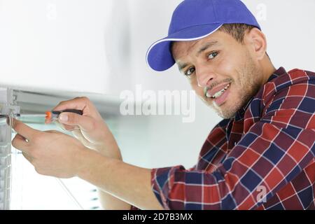 worker fasten the handle to a plastic window Stock Photo