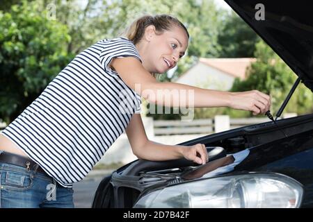 a happy woman fixing car Stock Photo