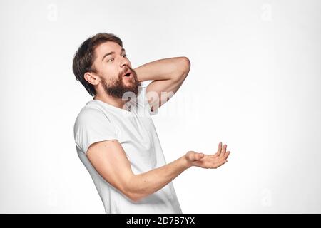 cheerful emotional bearded man gesturing with his hands close-up light background Stock Photo