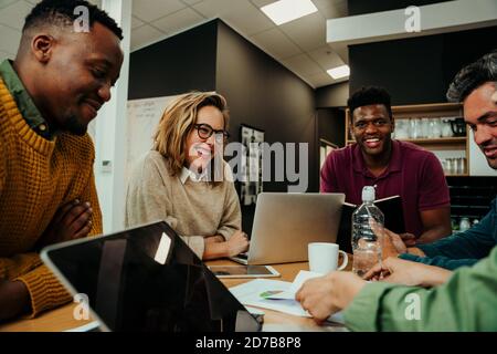 Business team gather together looking happy discussing presentation approach before meeting with boss Stock Photo