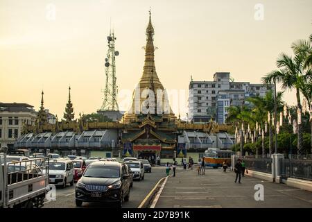 Yangon, Myanmar - December 30, 2019: View of the golden buddhist Sule Pagoda with cars in traffic in front of the stupa Stock Photo