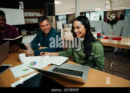 Woman laughing at colleagues during lunch break making jokes before interview Stock Photo