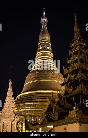 Yangon, Myanmar - December 30, 2019: The top of two golden structures against the dark night sky at the Shwedagaon Pagoda Stock Photo