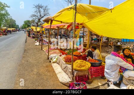 Stalls selling fresh local produce and steet food in a busy roadside market in a village in Madhya Pradesh, India Stock Photo