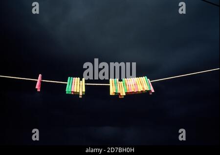 AJAXNETPHOTO. SOUTHAMPTON, ENGLAND. - STORM PEGS - A ROW OF COLOURED PLASTIC CLOTHES PEGS ON A WASHING LINE AGAINST THREATENING STORM-CLOUDS.PHOTO:JONATHAN EASTLAND/AJAX REF:71108 11 Stock Photo