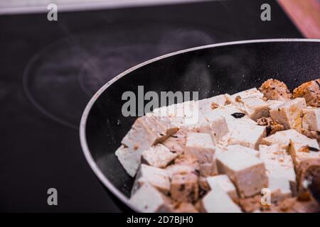 Macro shot of fried tofu mix in oil making smoke Stock Photo