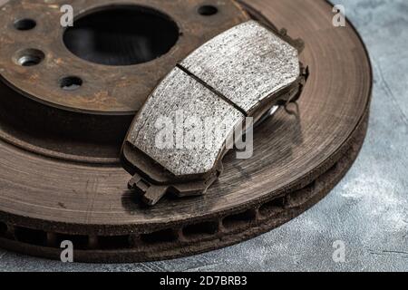 Old worn out car brake disc and brake pads, macro shot close-up. Stock Photo