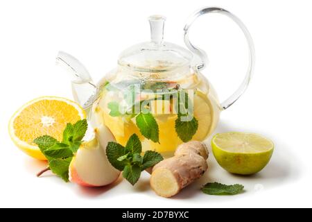 isolated glass transparent teapot with tea from ginger root, lime, orange, apple, mint Stock Photo