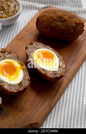 Homemade Scotch Eggs on a rustic wooden board, side view. Close-up. Stock Photo