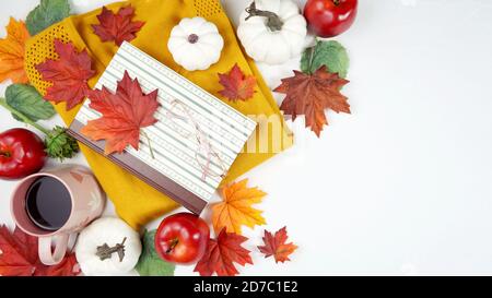 Autumn Fall Thanksgiving relaxation hygge theme flatlay with gold sweater, reading glasses and book and scattered maple leaves background. Top down cr Stock Photo