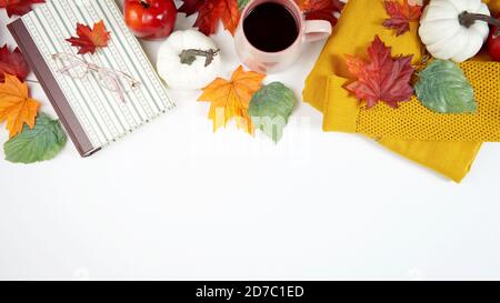 Autumn Fall Thanksgiving relaxation hygge theme flatlay with gold sweater, reading glasses and book and scattered maple leaves background. Top down cr Stock Photo