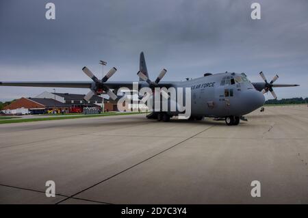 Shiloh, IL--Sept 12, 2012; front view of a ghost grey C-130 Hercules military transport turboprop aircraft parked on a tarmac with a cloudy sky