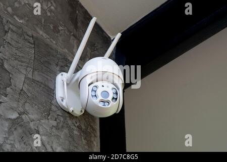 Round shape security camera hanging on wall to monitor movement around. Stock Photo
