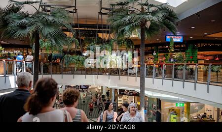 Brisbane, Queensland, Australia - 28th September 2019: People on an escalator under tropical decor at Carindale Shopping Centre Stock Photo