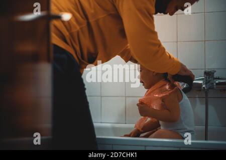 Father cutting son's hair at home during the 2020 pandemic lockdown. Covid-19 social distancing Stock Photo