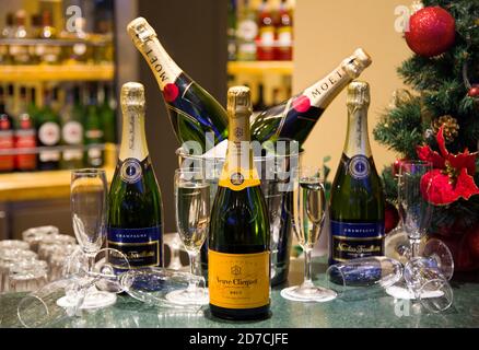 Luxury champagnes Veuve Clicquot, Moët & Chandon & Nicolas Feuillatte with flutes and a Christmas tree background. Christmas party. New Year's eve Stock Photo