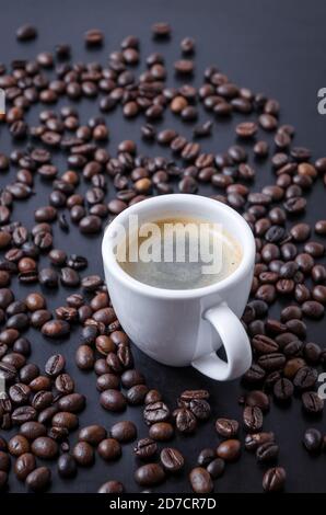 Roasted coffee espresso beans on dark background and cup with crema, close-up, flat lay, background, still life, hot beverage, I love coffee concept Stock Photo