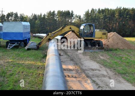 Excavator digs a trench for the construction of a gas pipeline Stock ...